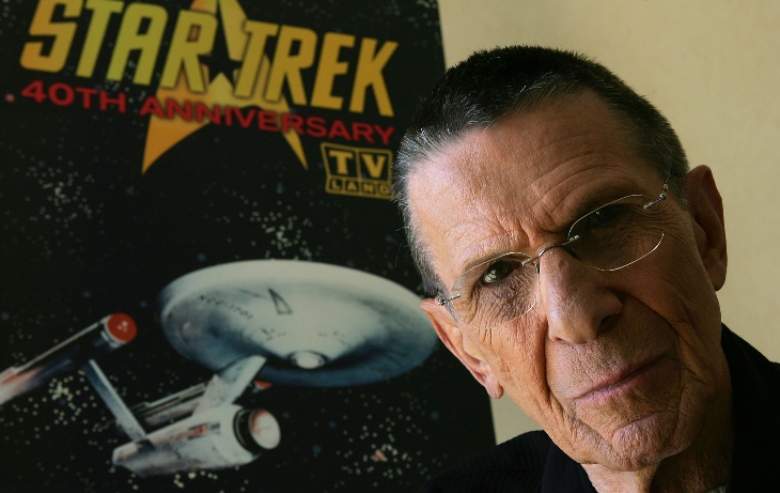 Leonard Nimoy poses in front of a vintage Star Trek poster