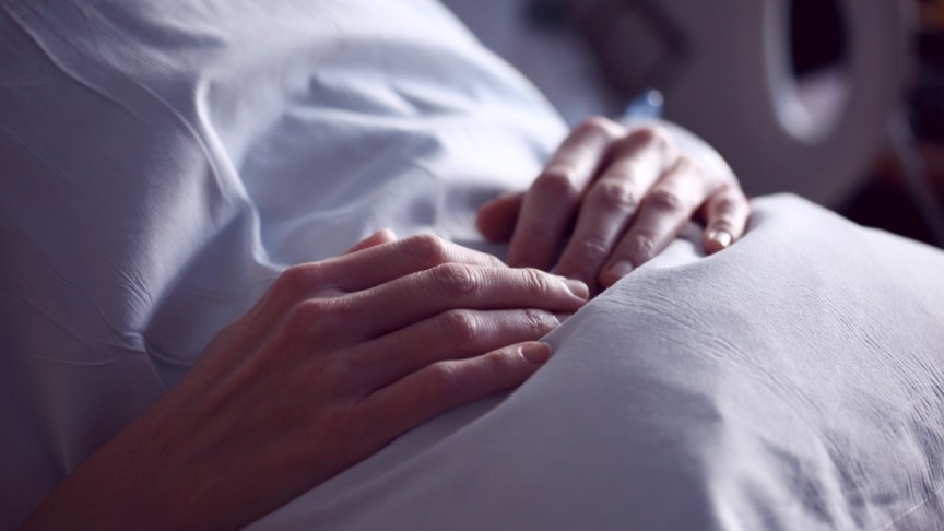 A woman in a hospital bed.