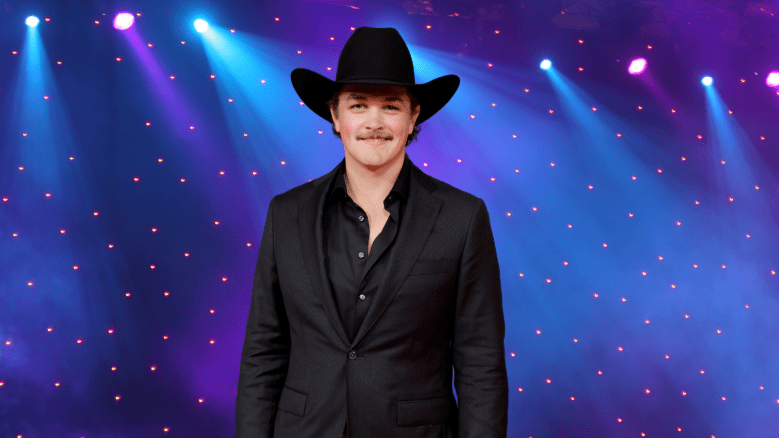 Zach Top poses in a black suit