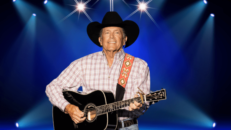 George Strait smiling while playing guitar