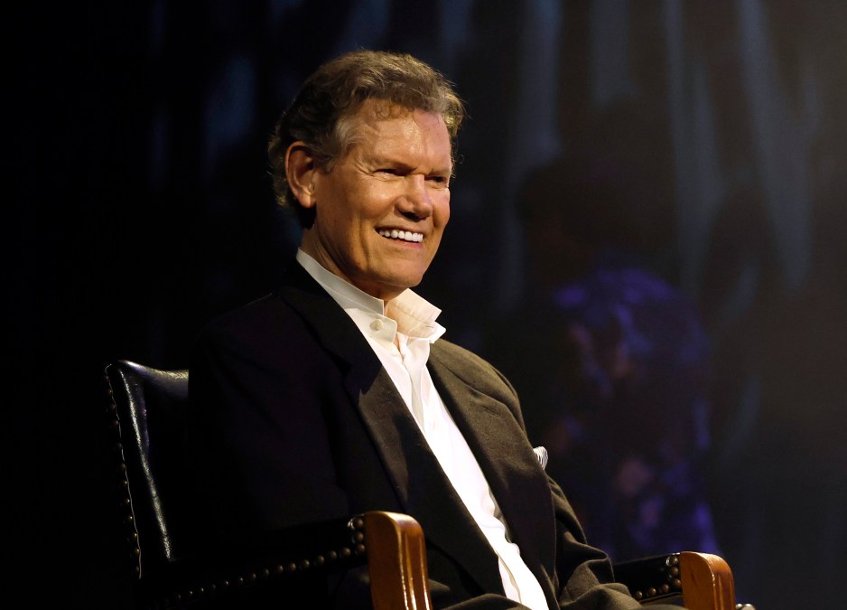 Randy Travis sitting on a stage