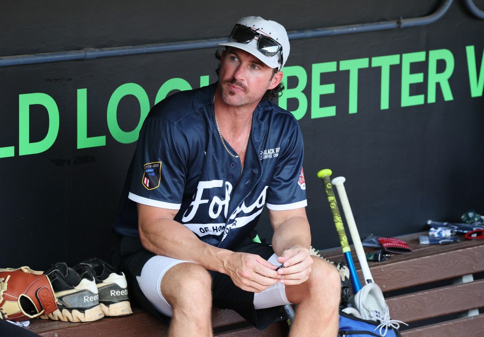 Riley Green sitting in a softball dugout