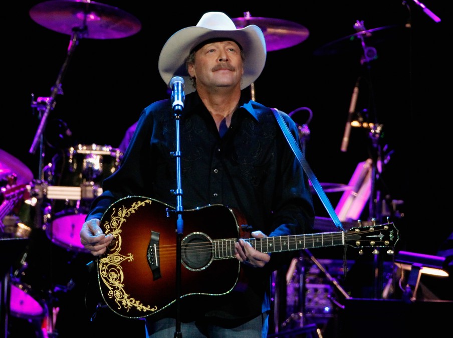 Alan Jackson holding a guitar on stage