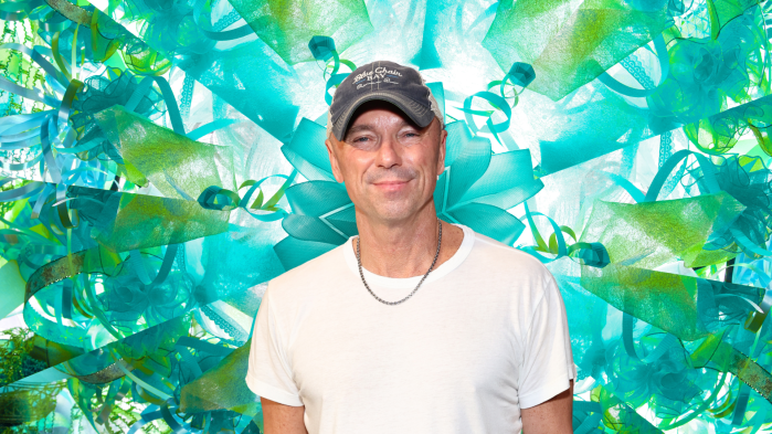 Kenny Chesney posing in front of a colorful background.