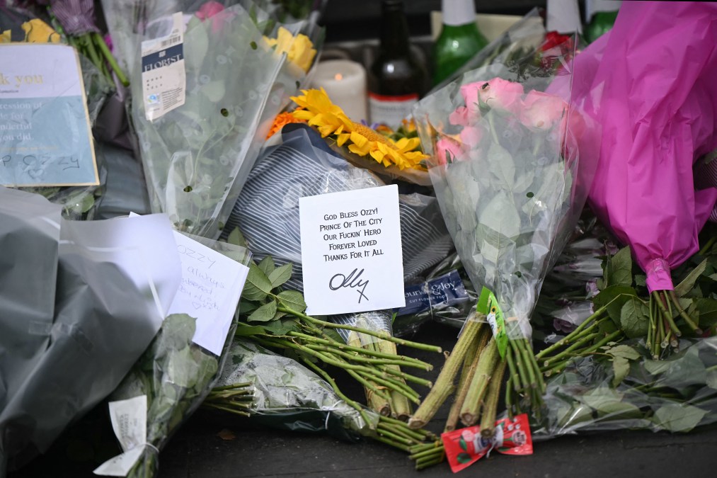 Flowers, candles and photos are left at a makeshift memorial on Black Sabbath Bridge