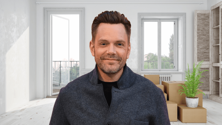 Joel McHale smiling in a house.