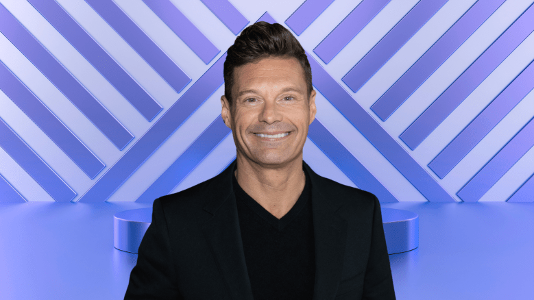 Ryan Seacrest posing on a stage