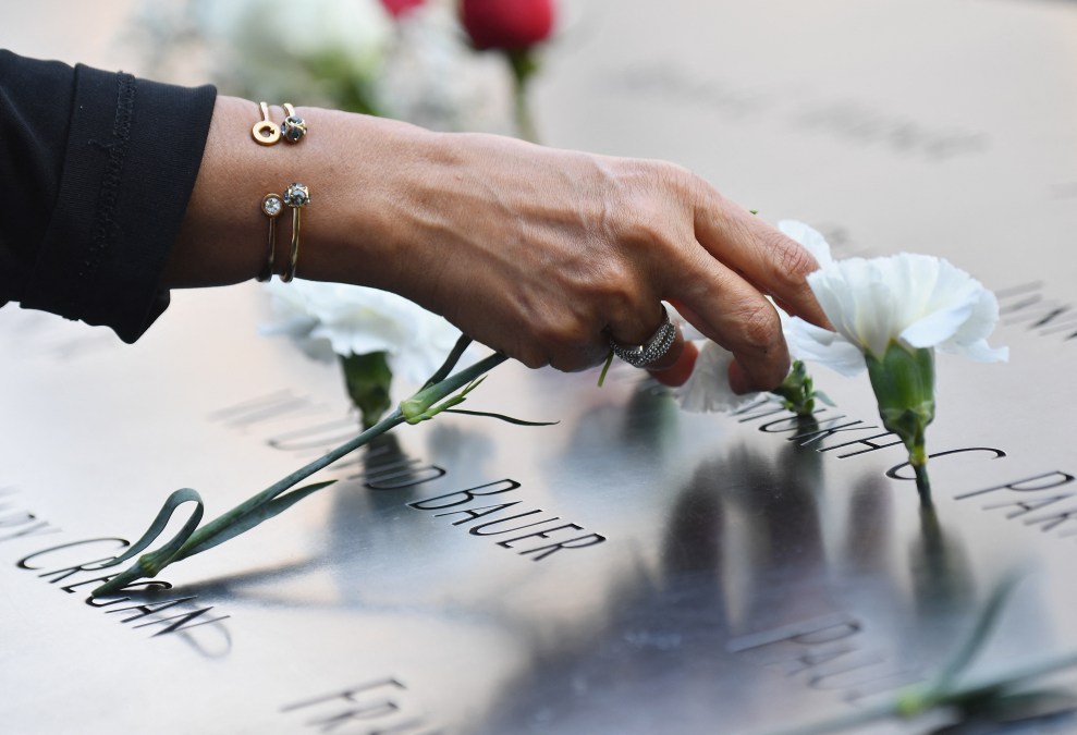 A mourner places flowers at the 9/11 Memorial & Museum 