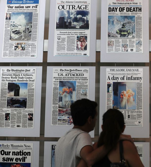 Visitors browse newspaper front pages with the story of the 9/11 terror attacks