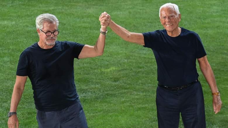 Italian fashion designer Giorgio Armani (R) and his historical collaborator Leo Dell'Orco acknowledge applause following the presentation of Giorgio Armani's Men's Spring Summer 2022 fashion collection