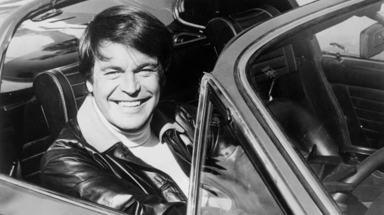 Robert Wagner smiling in a car
