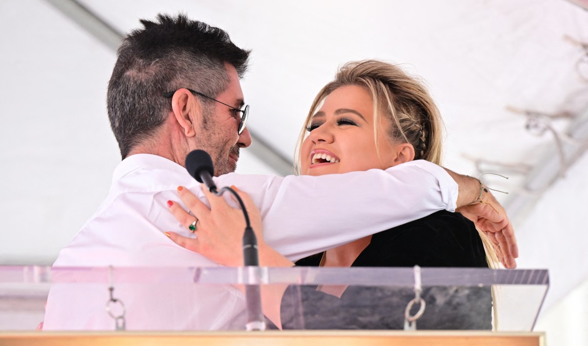 Kelly Clarkson and Simon Cowell embrace
