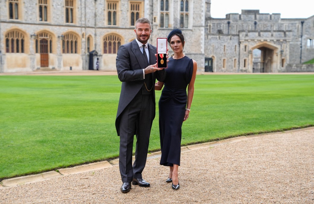 Former England footballer David Beckham (L) poses next to his wife singer and fashion designer Victoria Beckham (R) 
