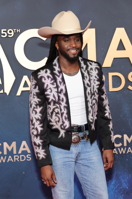 Shaboozey smiling at the CMA arrivals