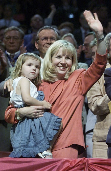 Liz Cheney waves to crowd while holding daughter