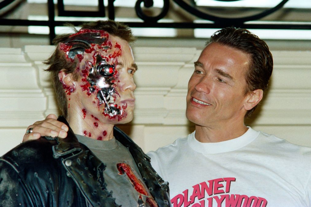 Arnold Schwarzenegger poses with a wax work of himself as Terminator