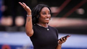 Simone Biles smiling and waving