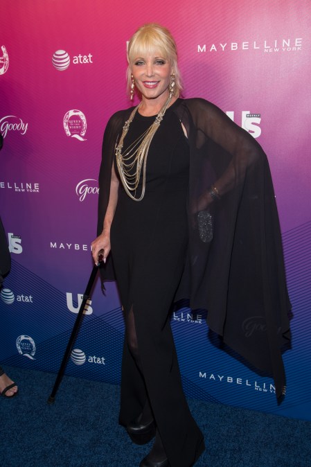 Pamela Bach smiling and walking with a cane