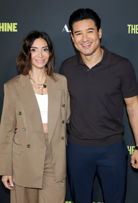 Courtney Lopez and Mario Lopez smile in taupe jacket and black shirt