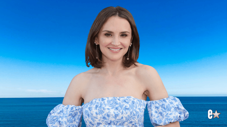 Rachael Leigh Cook smiles in blue floral dress