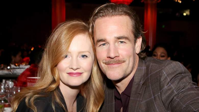 Kimberly and James Van Der Beek sit together at an event.