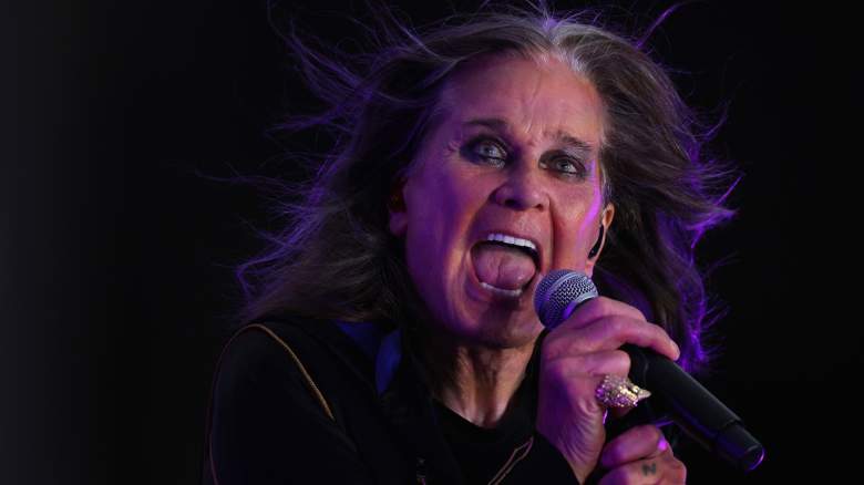 Ozzy Osbourne sings loudly into a microphone on stage.